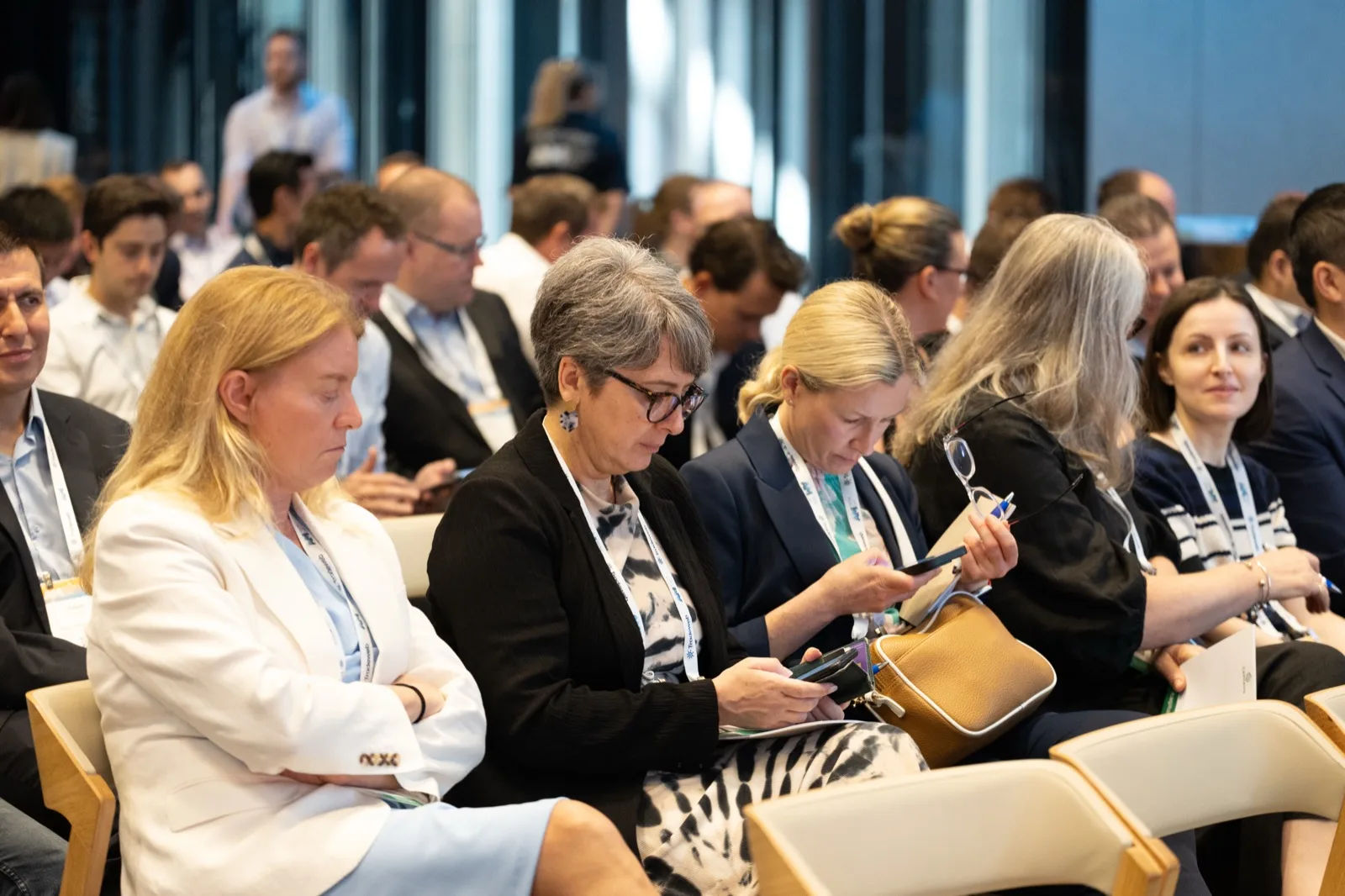 Attendees taking notes during a conference session
