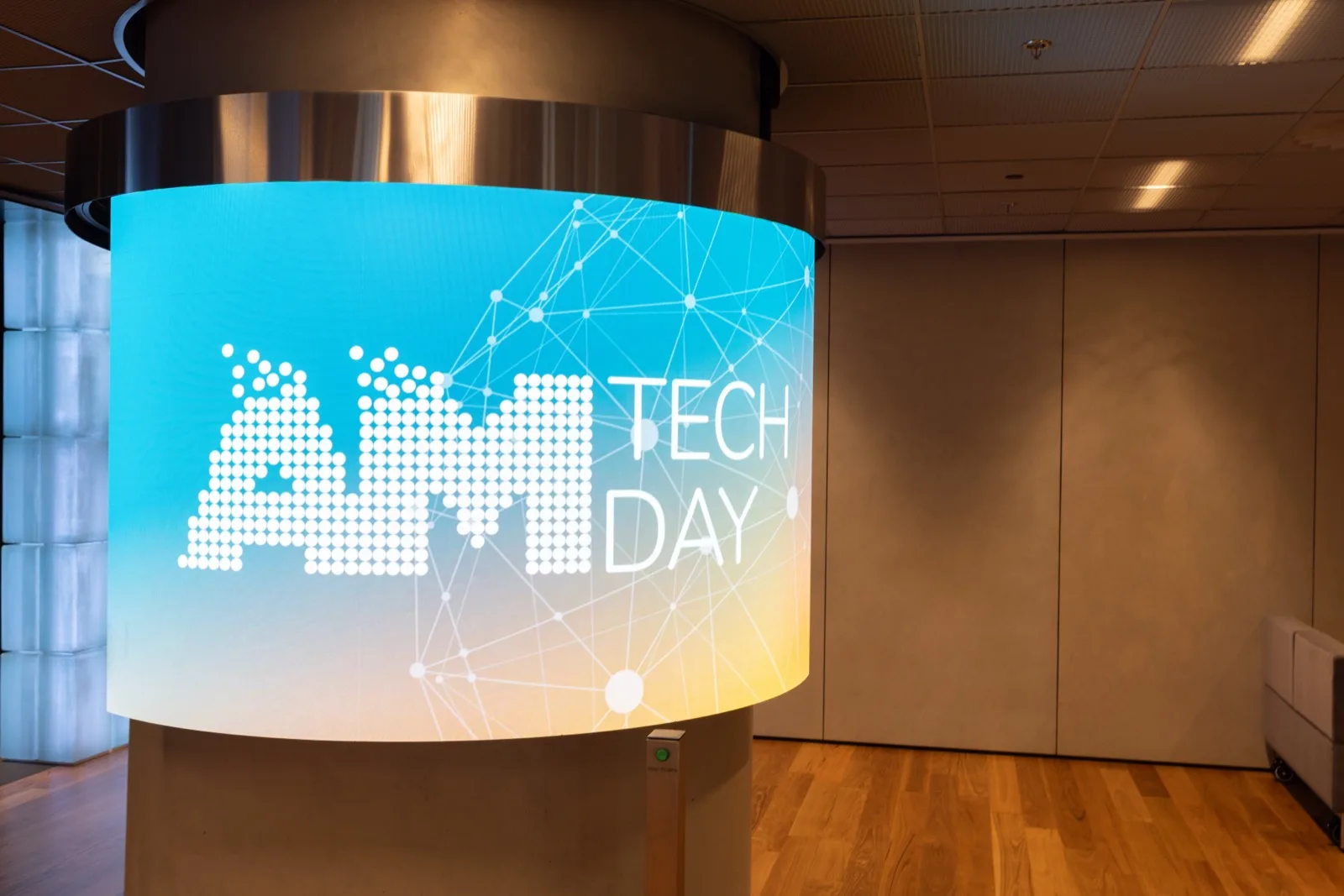 AM Tech Day APAC branding on a curved LED display in the venue foyer